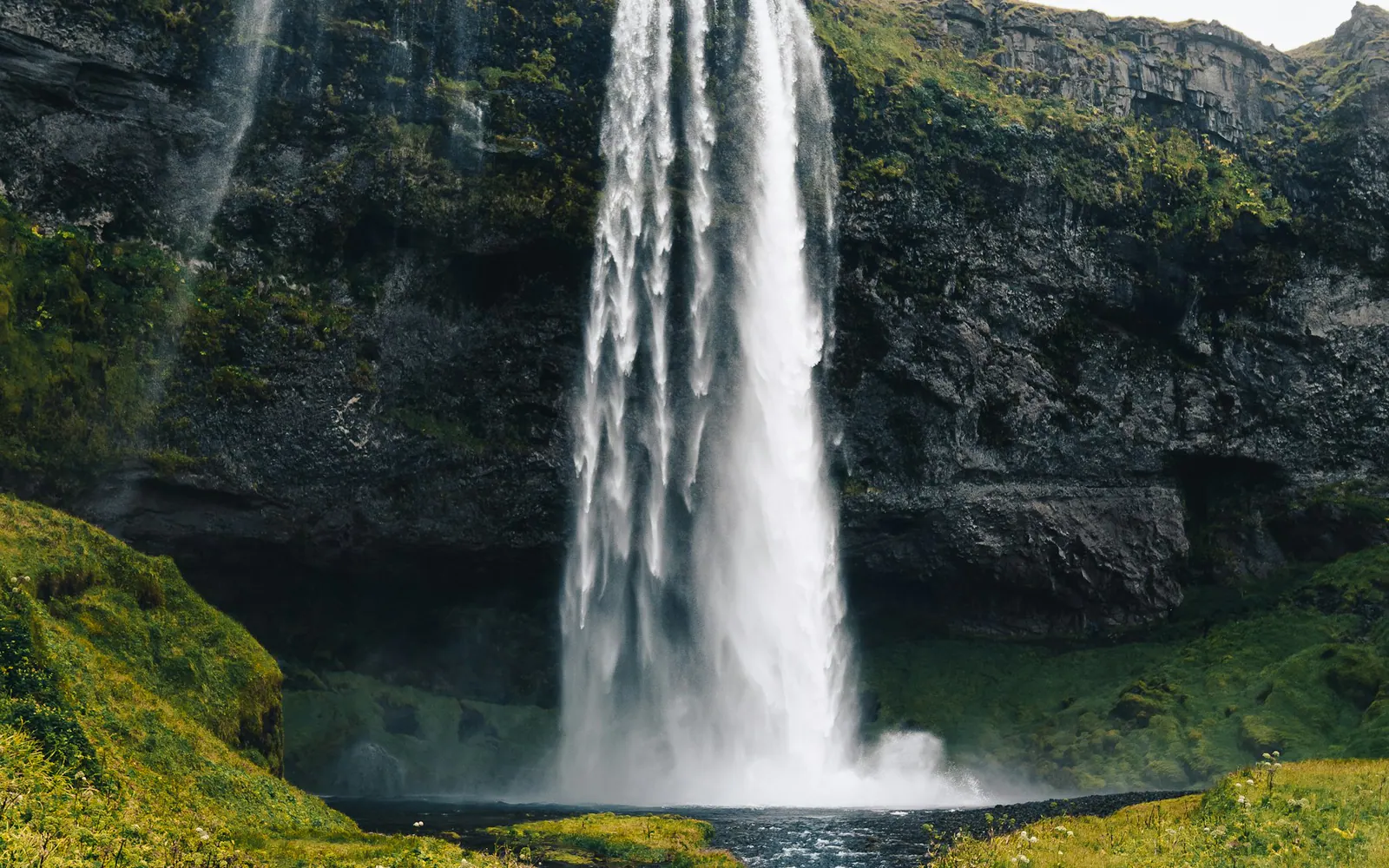 A waterfall descending over a mossy cliff